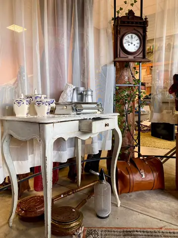 Une horloge de parquet ancienne et une console avec pots en faïence, dans le rayon mobilier.