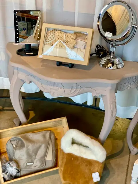 Une console en bois patinée, avec miroirs et petits objets, dans le rayon mobilier.