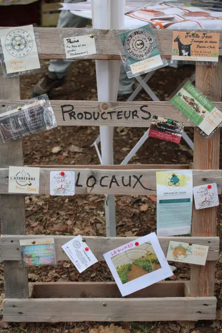 Un panneau en palette « Producteurs locaux » couvert des cartes des exposants de la Fête des Possibles 2024.